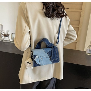 Détail du sac bandoulière en denim patchwork avec charme en peluche sur blazer beige