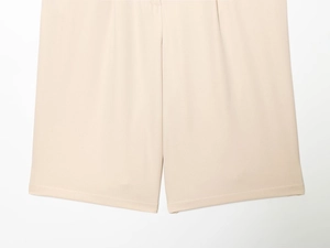 Détail de short large beige clair présentant un tissu fluide et des coutures soignées
