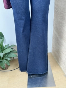 Detail view of dark blue flare jeans leg silhouette and denim fabric on a mannequin