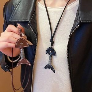 Detail of leather fishbone pendant necklaces in black and brown on a model