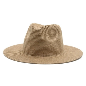 Detailed close-up of handmade woven texture and wide brim on khaki straw fedora hat