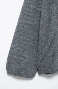 Close-up of the grey chunky knit fabric showing detailed vertical ribbed texture and soft material
