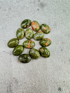 Macro shot of polished oval unakite stone cabochons for handmade jewelry DIY projects