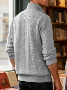 Close-up of light grey cable knit sweater featuring high collar and rib-knit cuffs texture