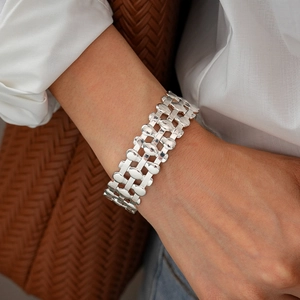 Detail of silver layered hollow mesh cuff bracelet on model with casual outfit