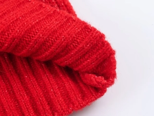 Close-up detail of dark red knitted fabric showing thick ribbed texture and wool fibers