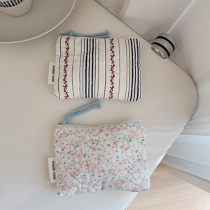 Detailed flat lay of quilted cotton coin purses with cherry embroidery and floral patterns