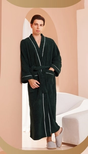 Detail of dark green plush bathrobe featuring white striped trim and belted waist tie