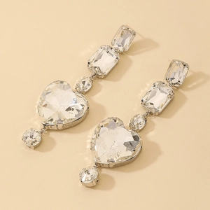 Macro detail of long geometric earrings featuring rhinestone heart and rectangle drops