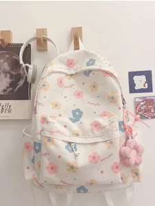 Cute cream-colored backpack with floral prints and a pink flower plush keychain for students