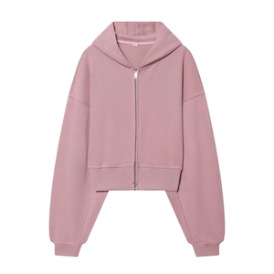 Détail d'un sweat à capuche court rose avec poignets côtelés et tissu polaire doux