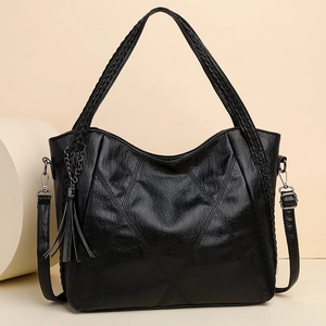 Minimalist black soft leather tote bag with woven handles and elegant chain tassel detail