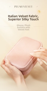 Pink plush velvet jewelry box with golden zipper closure held in hand for scale and detail