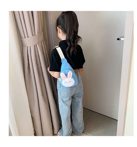 Detail of light blue canvas bunny chest bag showing the adjustable strap and back view on a child
