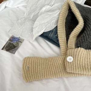 Detail of knit balaclava with two-tone grey and cream wool and white button closure