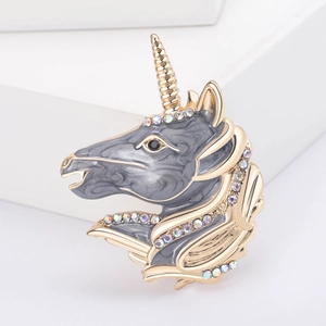 Unicorn enamel brooch with rainbow rhinestones and gold-tone frame on white background
