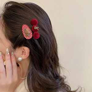Detail view of a model wearing red flocked ball and polka dot bear hair clips