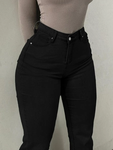 Detail shot of black high waisted flared jeans showing slimming fit and pocket design
