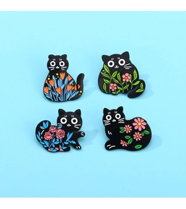Detail showing set of four cartoon black cat enamel pins with floral patterns