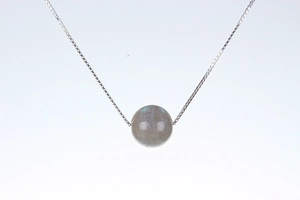 Macro shot of spherical labradorite pendant with blue sheen on fine silver chain