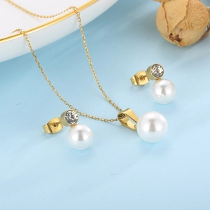 Détail de l'ensemble collier et boucles d'oreilles en acier doré 18K et perles blanches