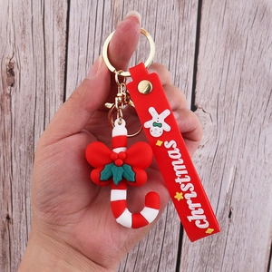 Detail of Christmas candy cane PVC keychain featuring a red bow strap and gold metal clasp