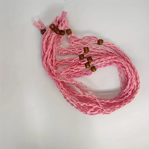 Detail view of handmade pink cotton cord macrame net bags with decorative wooden beads
