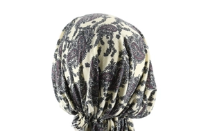Rear view of cream paisley headscarf with detailed blue and red patterns on model
