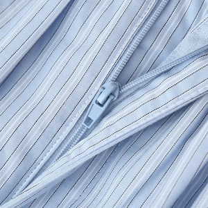 Close-up of blue striped fabric with a matching invisible zipper on a women's shirt set