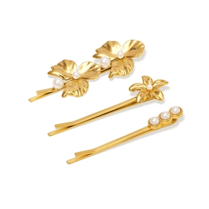 Détail de 3 barrettes dorées à l'or 18 carats avec fleurs en nacre et perles blanches