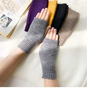 Close-up of gray knitted fingerless gloves for women with multi-color options background