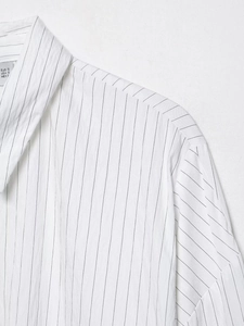 Close-up of a white striped cotton shirt showing collar details and size label