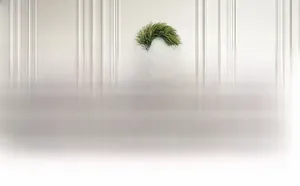 Detailed view of a 26 inch artificial pine needle Christmas wreath on a home fireplace