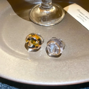Detail of amber and grey resin geometric rings on a warm ceramic tray with elegant lighting