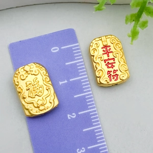 Macro view of gold alloy lucky charms with engraved Fu and Ping An symbols and ruler