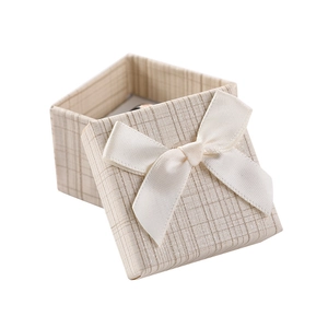 Elegant square cream jewelry gift box with textured grid pattern and silk bow detail