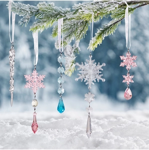 Macro detail of acrylic crystal snowflakes and icicles hanging on snowy pine branches