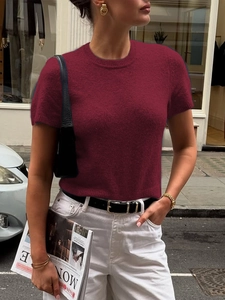 Photo street style d'un haut en maille texturée bordeaux avec un jean blanc et ceinture