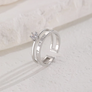 Close-up of crown-set zircon and Roman numeral engravings on double-layer silver ring