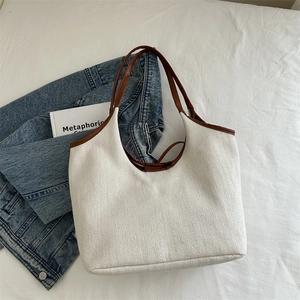 Large white textured tote bag with brown leather handles and casual style for daily commute