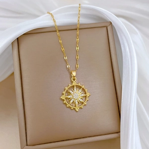 Detailed macro of gold sunburst starburst pendant with sparkling zircon on silk cushion