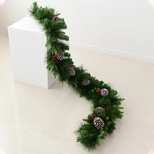 Artificial Christmas pine garland with snowy cones and red berries for holiday home decor