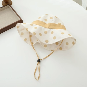 Close-up of kids sun hat with yellow polka dots and adjustable chin strap