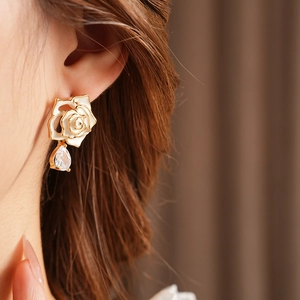 Détail de boucles d'oreilles fleurs vintage avec émail et goutte en zircone poire