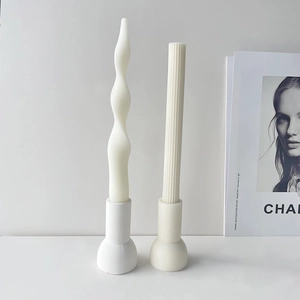 Detail of minimalist ribbed and wavy white scented candles on cylindrical bases