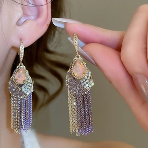 Close-up of vintage teardrop earrings with elegant purple and gold chain tassels