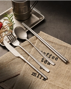 Close-up of vintage snowflake grey stainless steel cutlery set on linen napkin