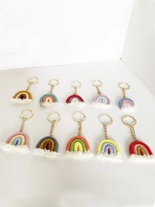 Flat lay of handmade macrame rainbow keychains in various colors with golden metal rings
