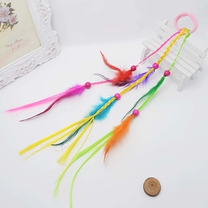Close-up of colorful feathered hair extensions with pink beads and bohemian braids
