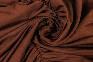 Detailed view of dark brown ribbed fabric with elegant vertical ruching and silky texture